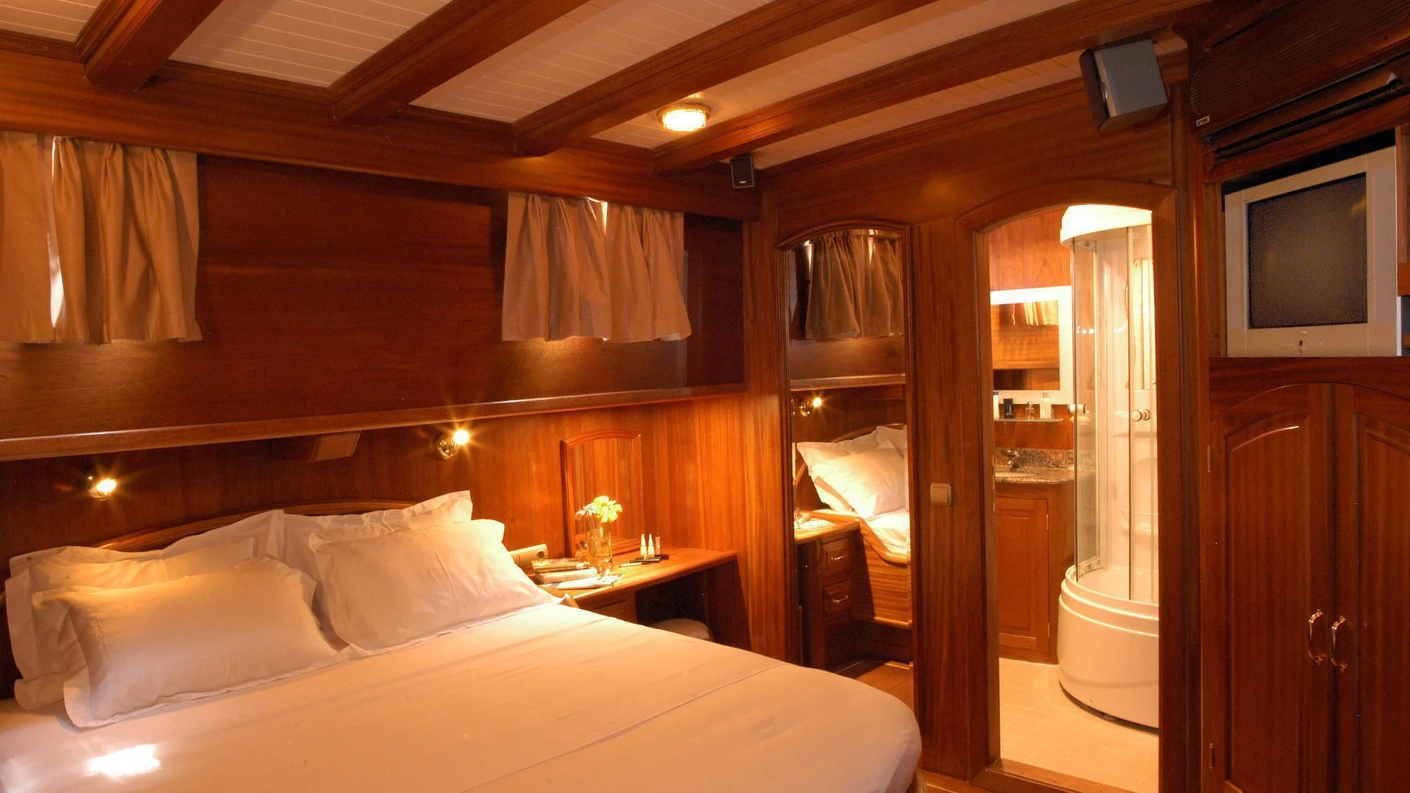 a hotel room with a bed and a television aboard QUEEN OF KARIA Yacht for Sale
