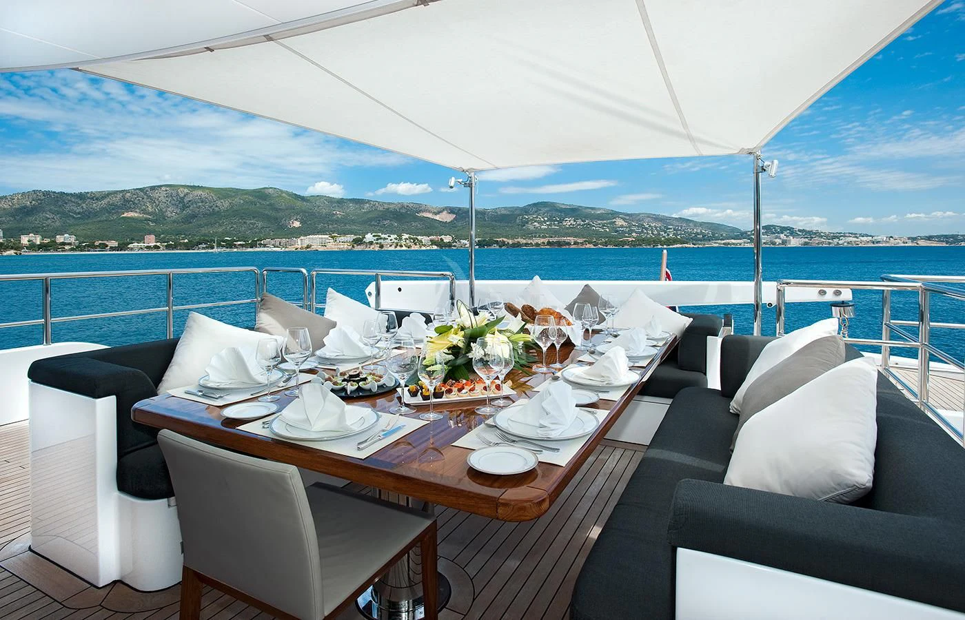 a table with chairs and a view of the ocean aboard CHRISTINA G Yacht for Charter