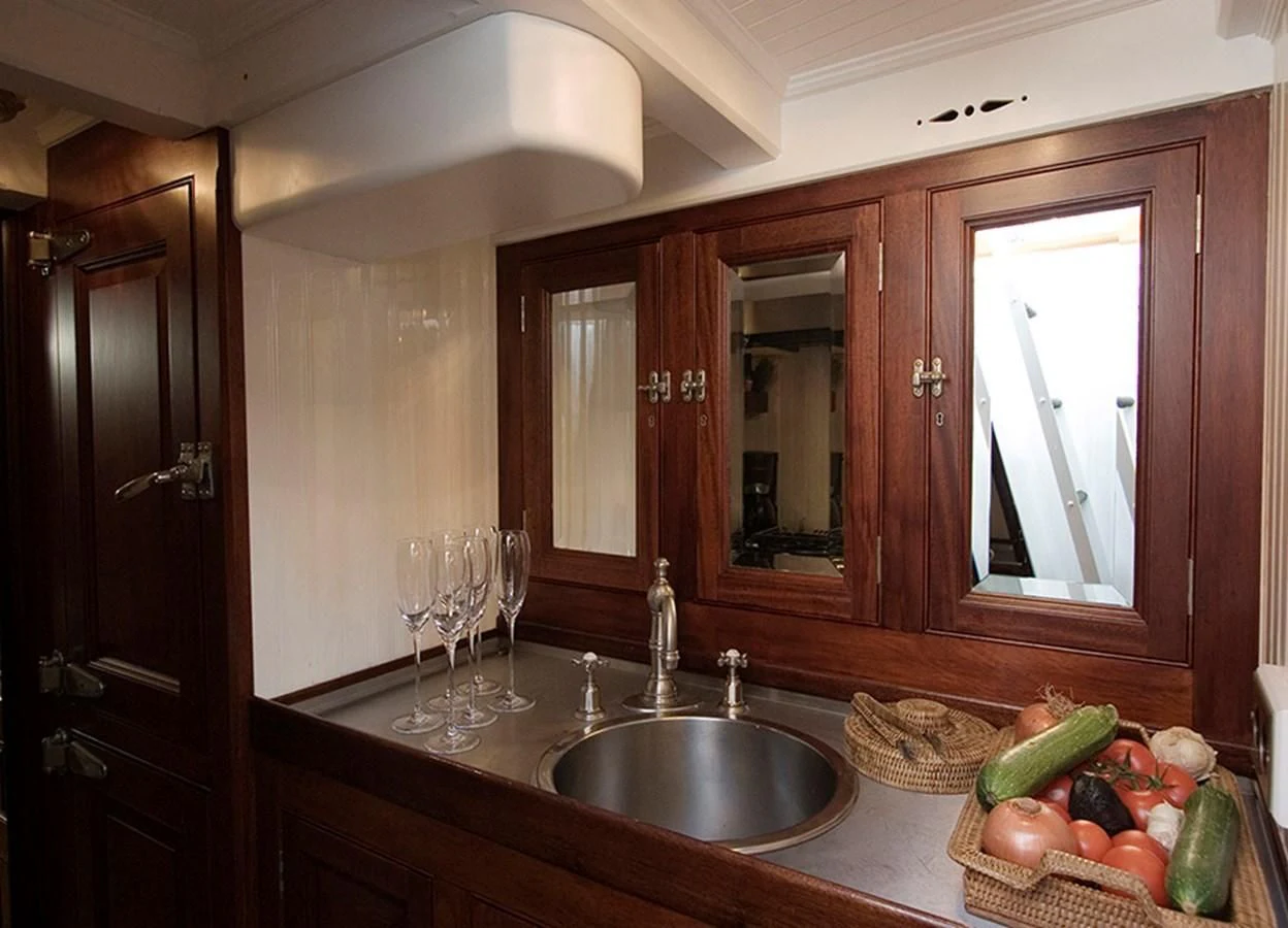 a kitchen with a sink and a basket of fruits aboard MOONBEAM OF FIFE III Yacht for Sale