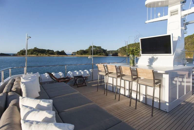 a deck with a television and chairs on it aboard RELENTLESS Yacht for Sale