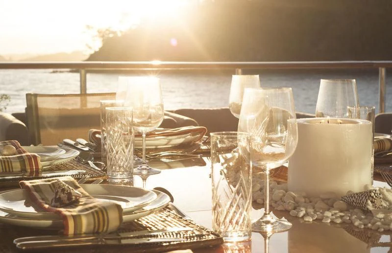 a table with wine glasses and plates aboard RELENTLESS Yacht for Sale