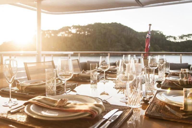 a table set with empty wine glasses aboard RELENTLESS Yacht for Sale