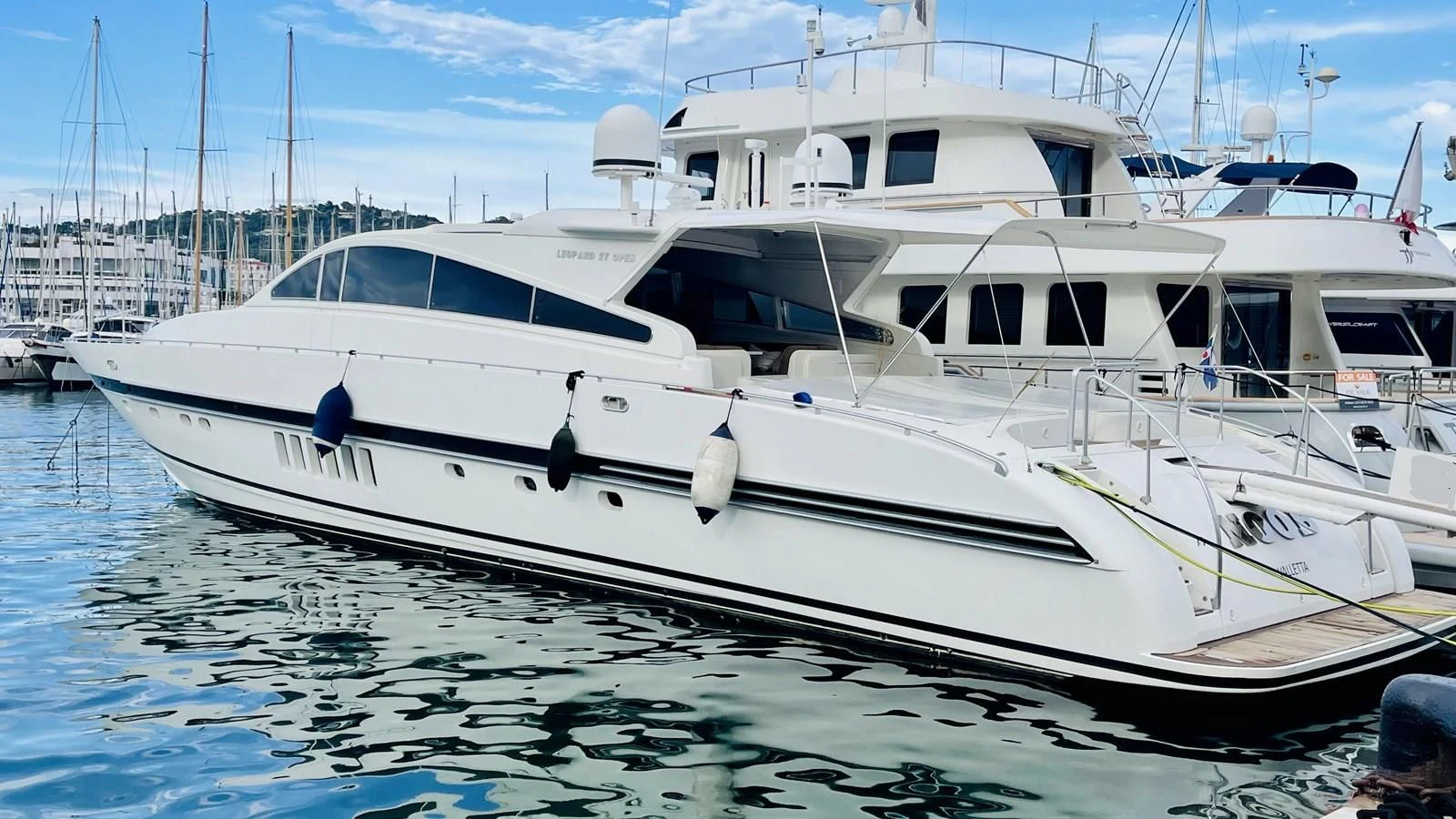 a white boat in a harbor aboard NOTORIOUS Yacht for Sale