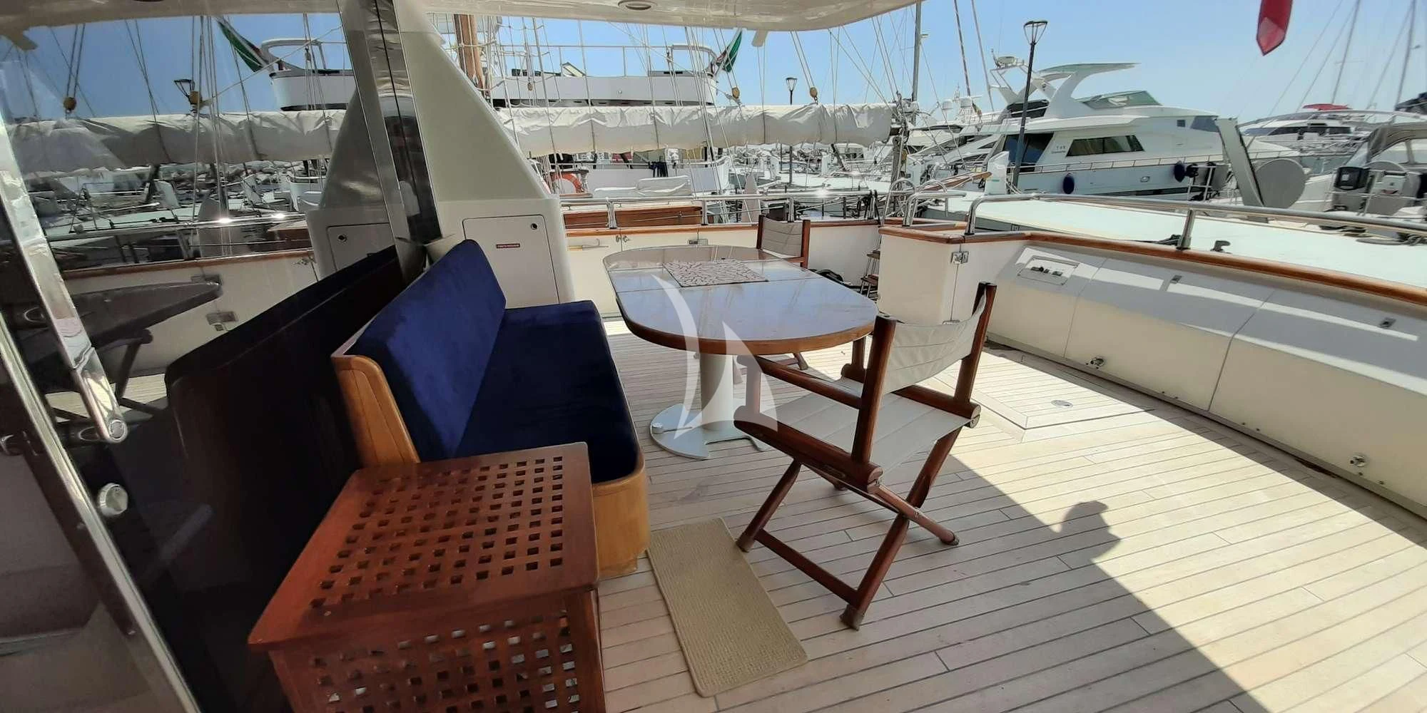 a deck with chairs and a table on it aboard OLA Yacht for Charter