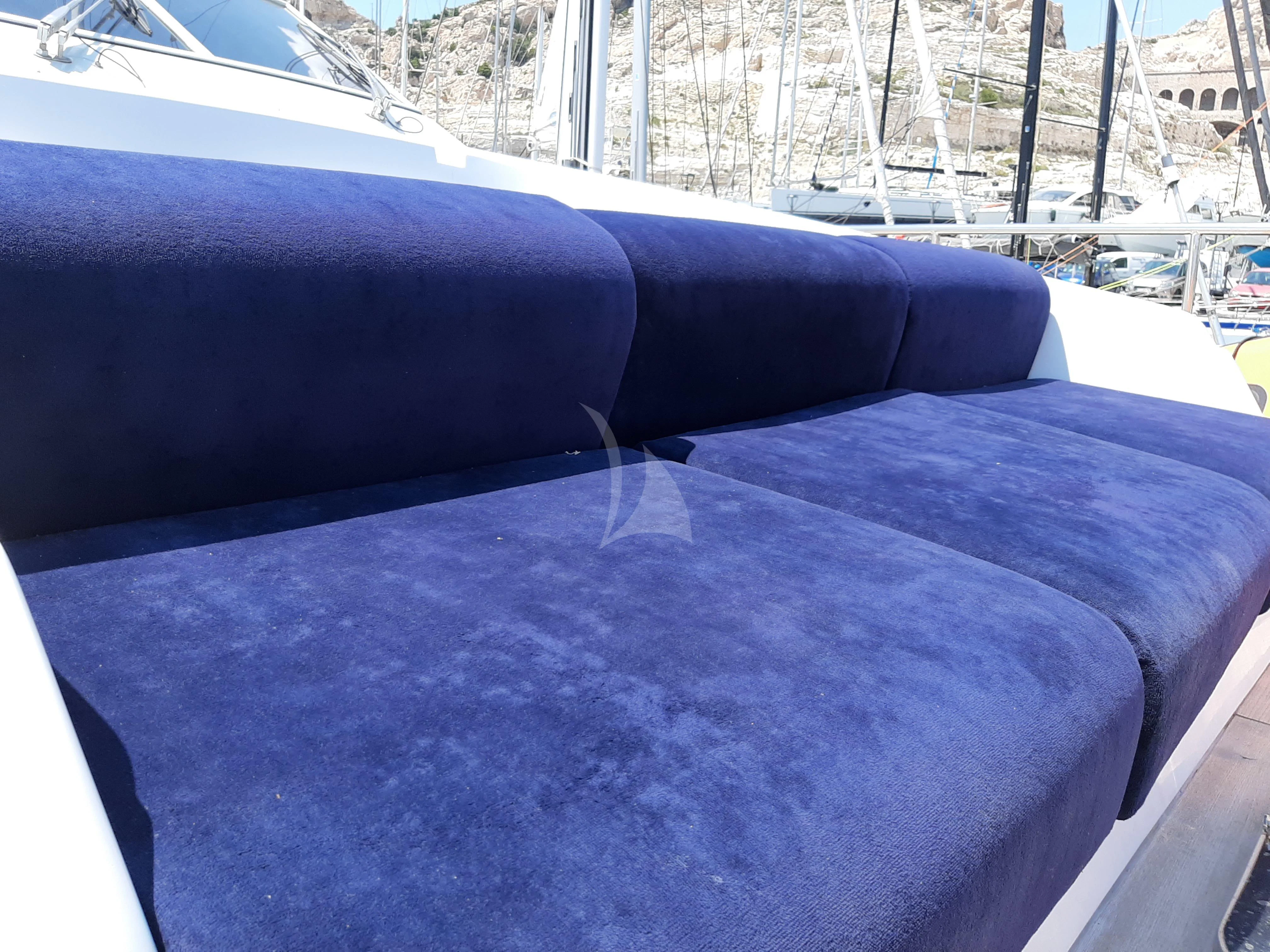 a blue couch on a deck aboard OLA Yacht for Charter