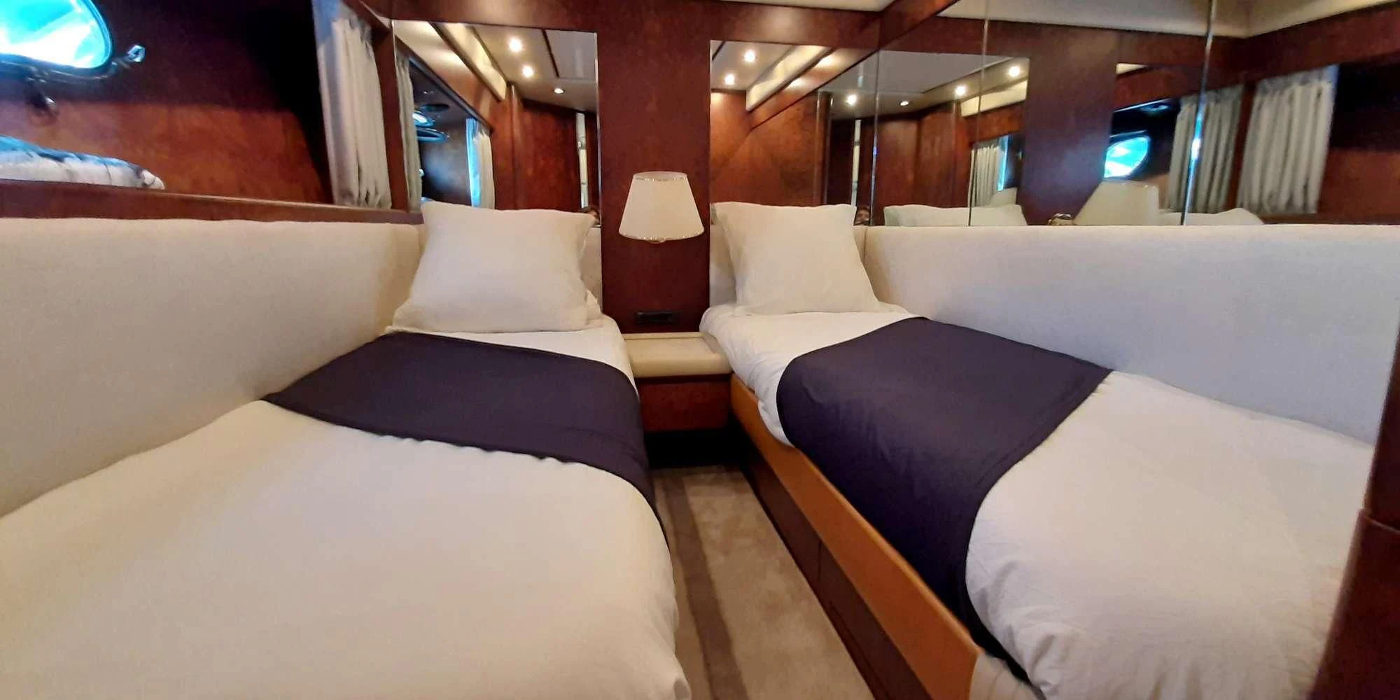 a room with beds and a table aboard OLA Yacht for Charter