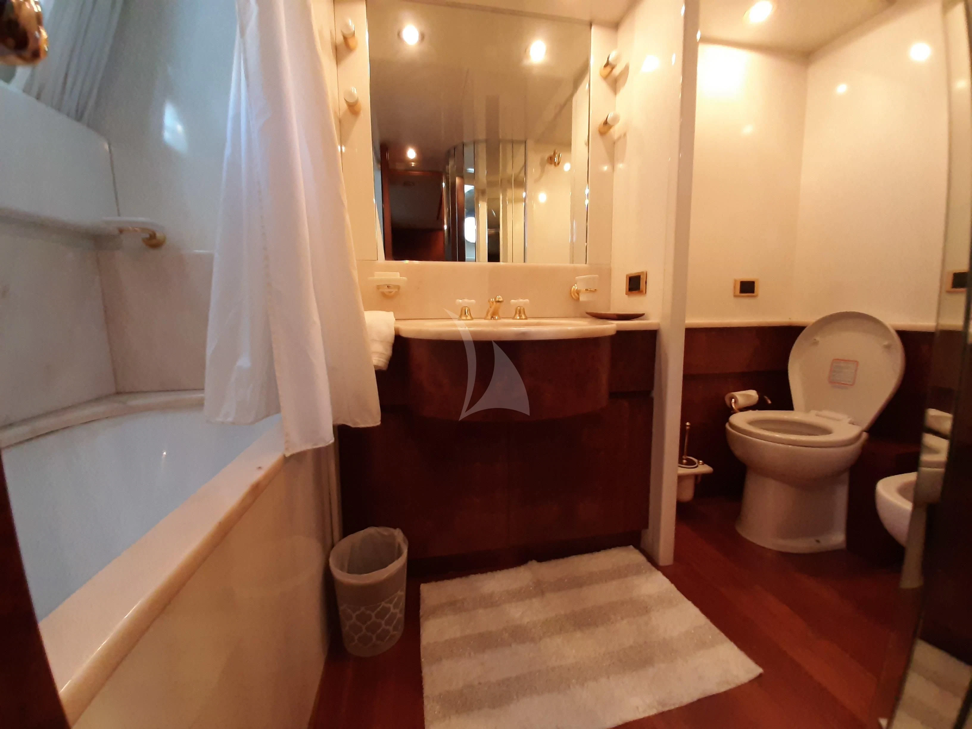 a bathroom with a tub sink and toilet aboard OLA Yacht for Charter
