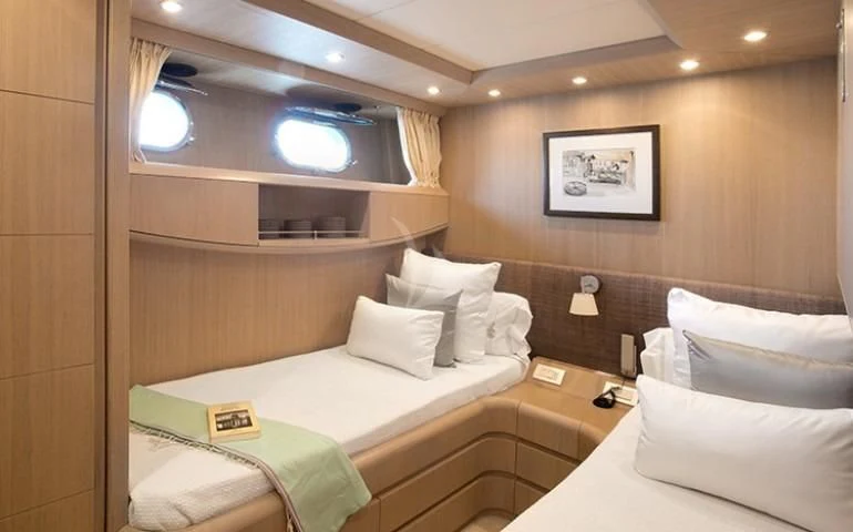 a room with beds and a television aboard GOTA Yacht for Sale
