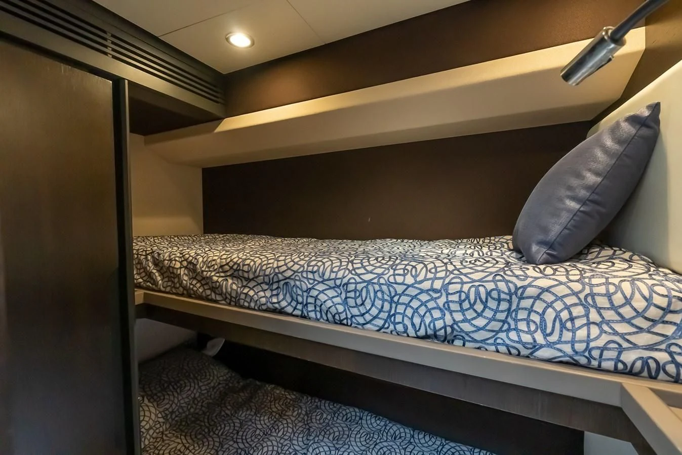 a bed with a blue sheet aboard PRIVE Yacht for Sale