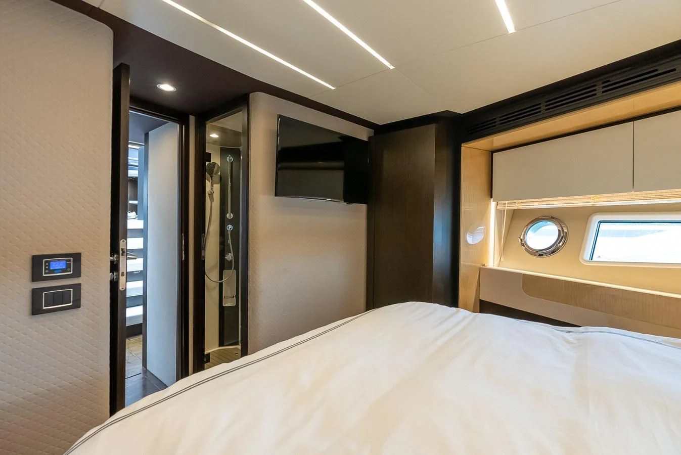 a bed with a white sheet and a mirror above it aboard PRIVE Yacht for Sale