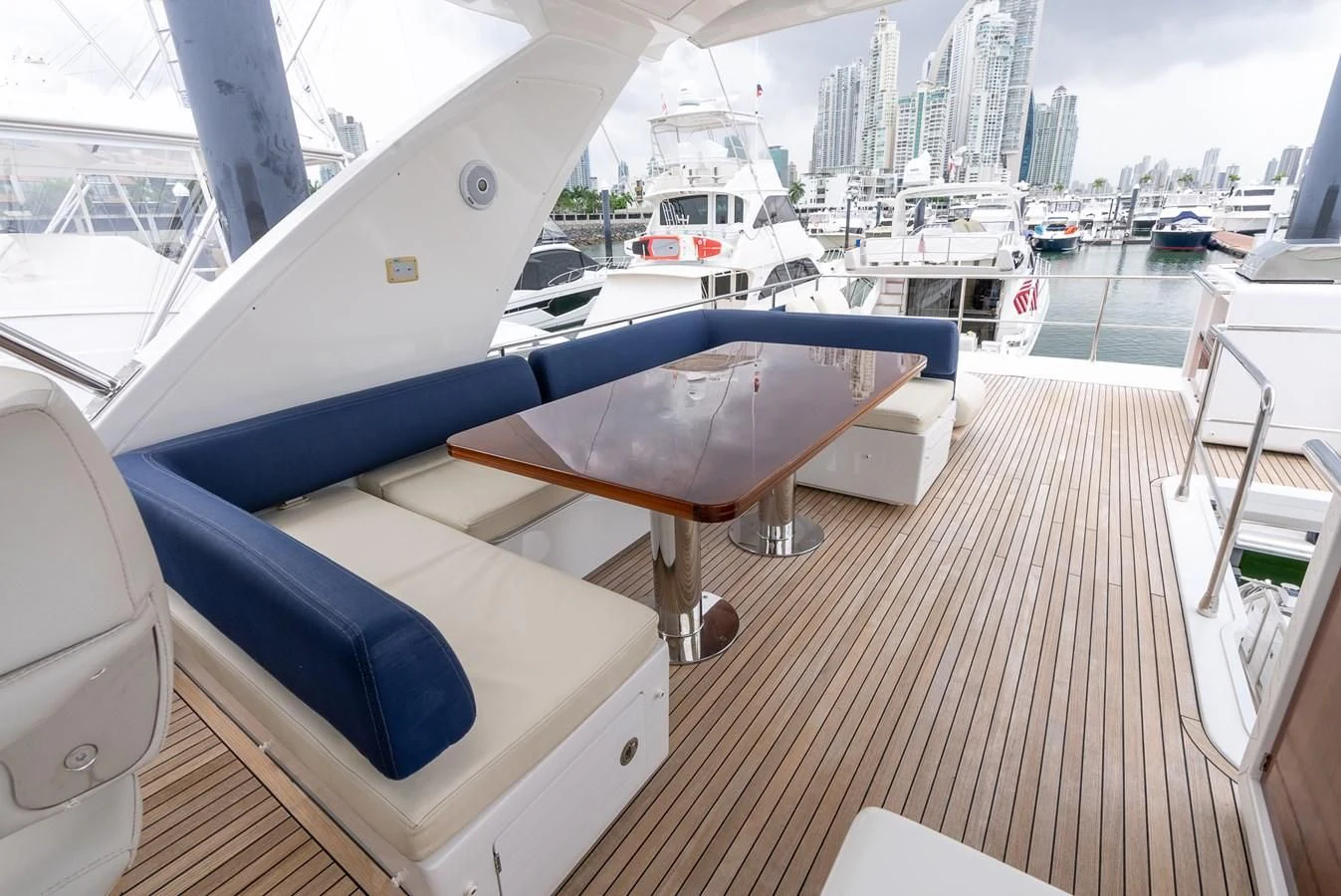 a deck with a boat and a city in the background aboard PRIVE Yacht for Sale