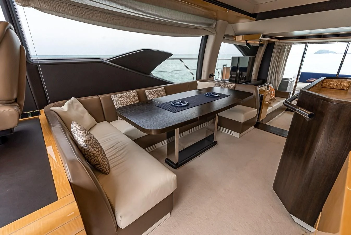 a living room with a table and couches aboard PRIVE Yacht for Sale