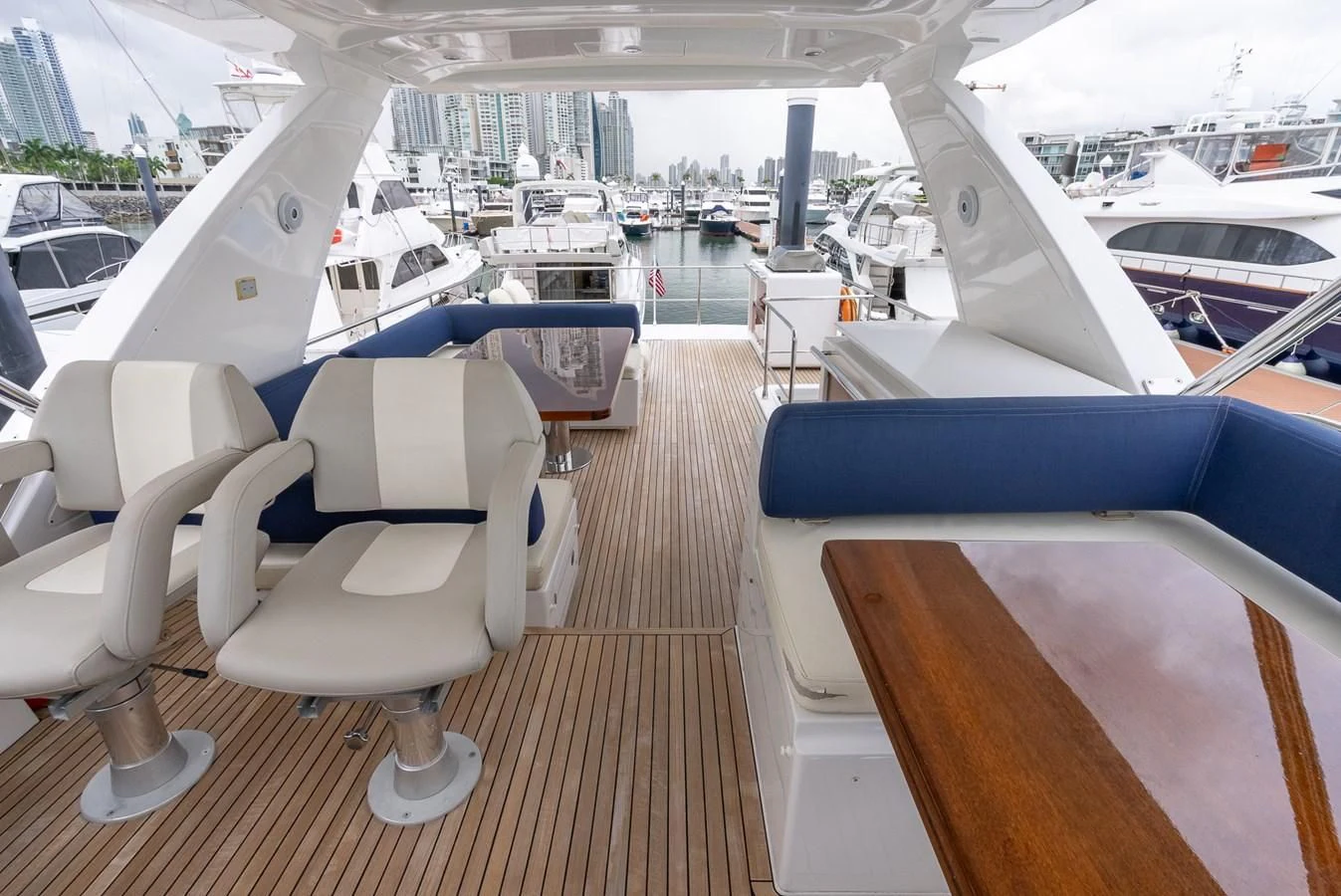 a room with a row of seats and tables with a view of the city and water aboard PRIVE Yacht for Sale