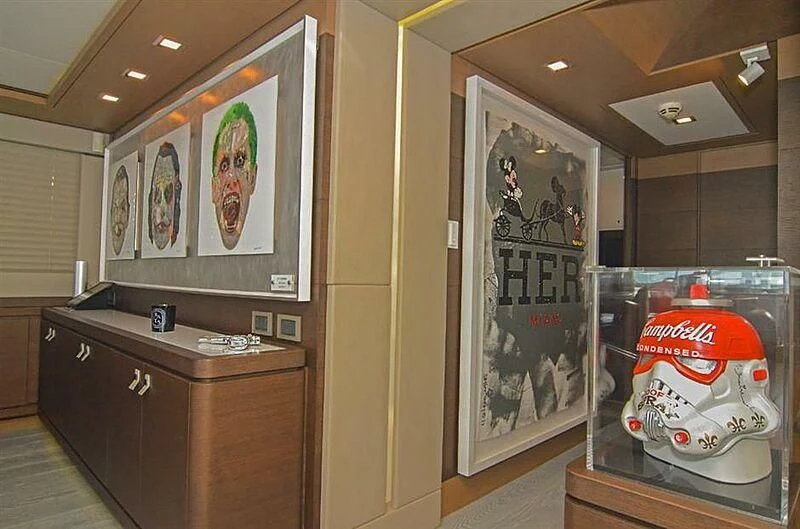a room with a cabinet and a counter with art on it aboard SE7EN Yacht for Sale
