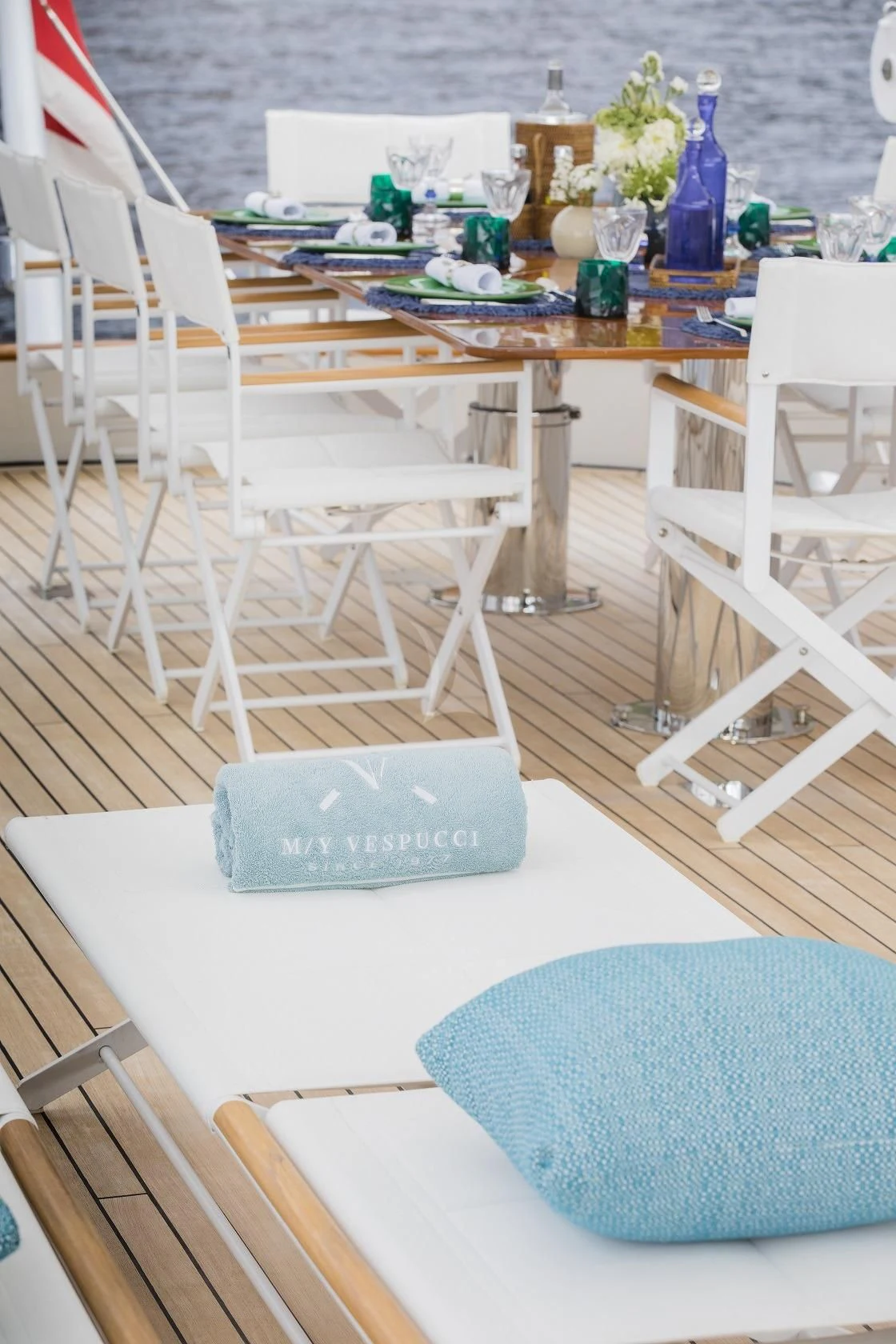 a table with chairs and a blue vase on it aboard VESPUCCI Yacht for Sale