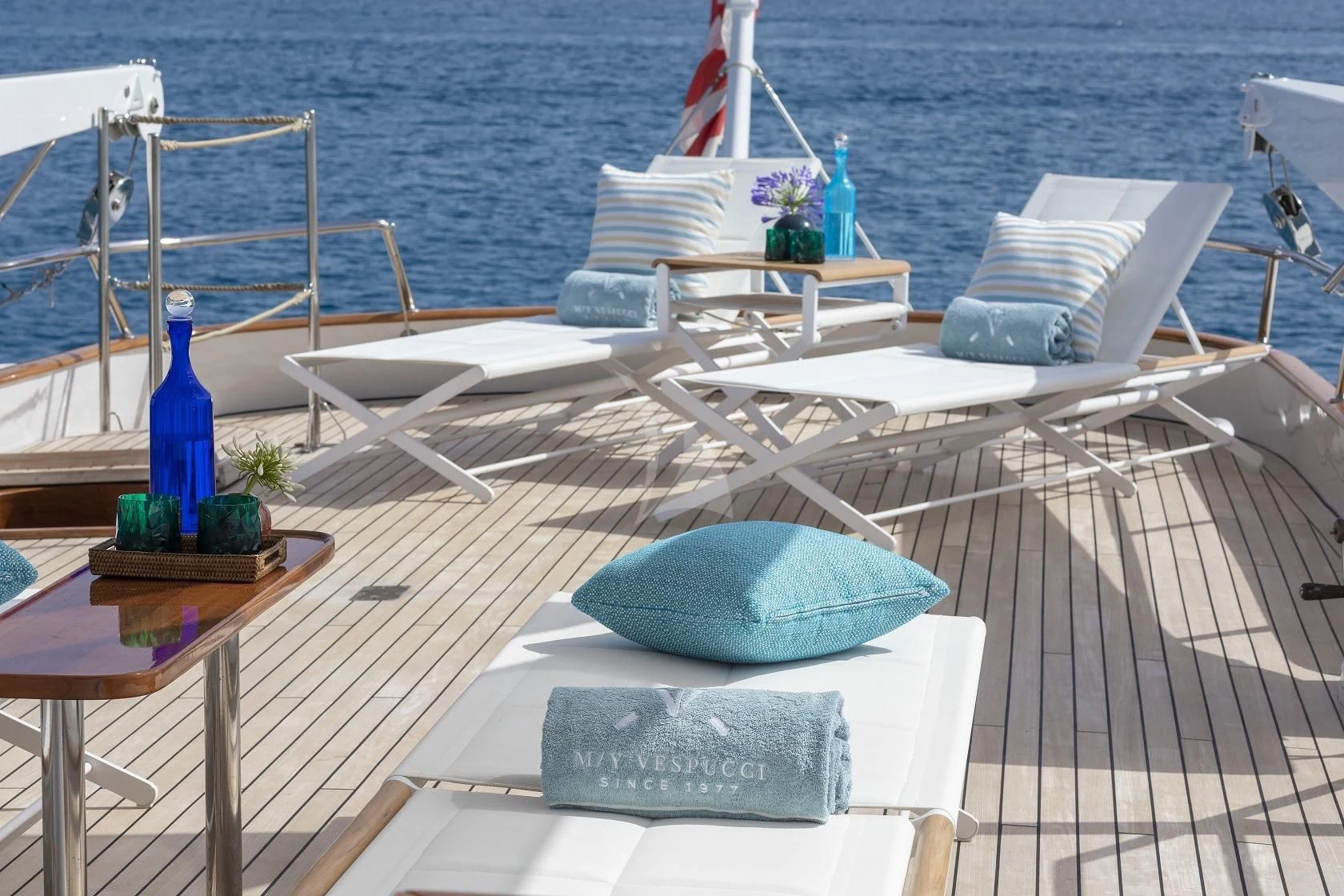 a deck with chairs and a table on it aboard VESPUCCI Yacht for Sale