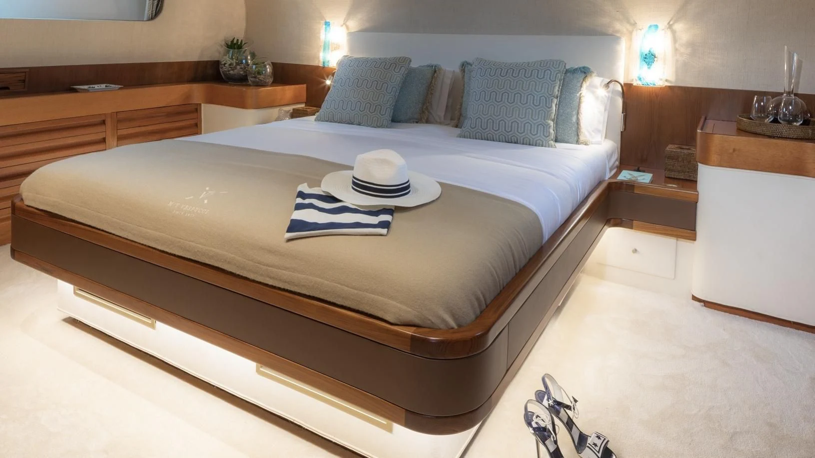 a bed with a white pillow and a blue pillow on it aboard VESPUCCI Yacht for Sale