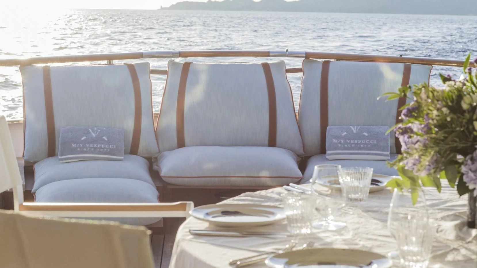 a table with chairs and a vase on it aboard VESPUCCI Yacht for Sale
