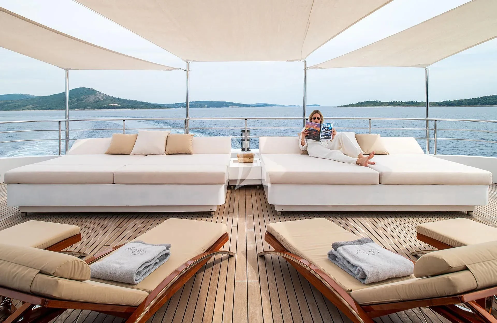 a couple of people sitting on a couch in a living room aboard TALEYA Yacht for Sale