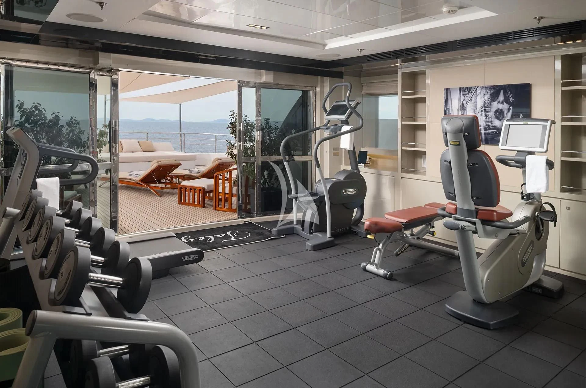a room with treadmills and a window aboard TALEYA Yacht for Sale