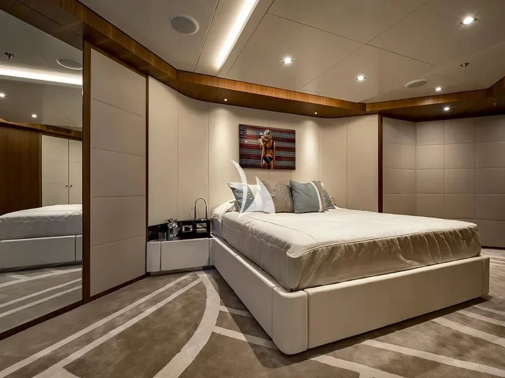 a room with a bed and a desk aboard TALEYA Yacht for Sale