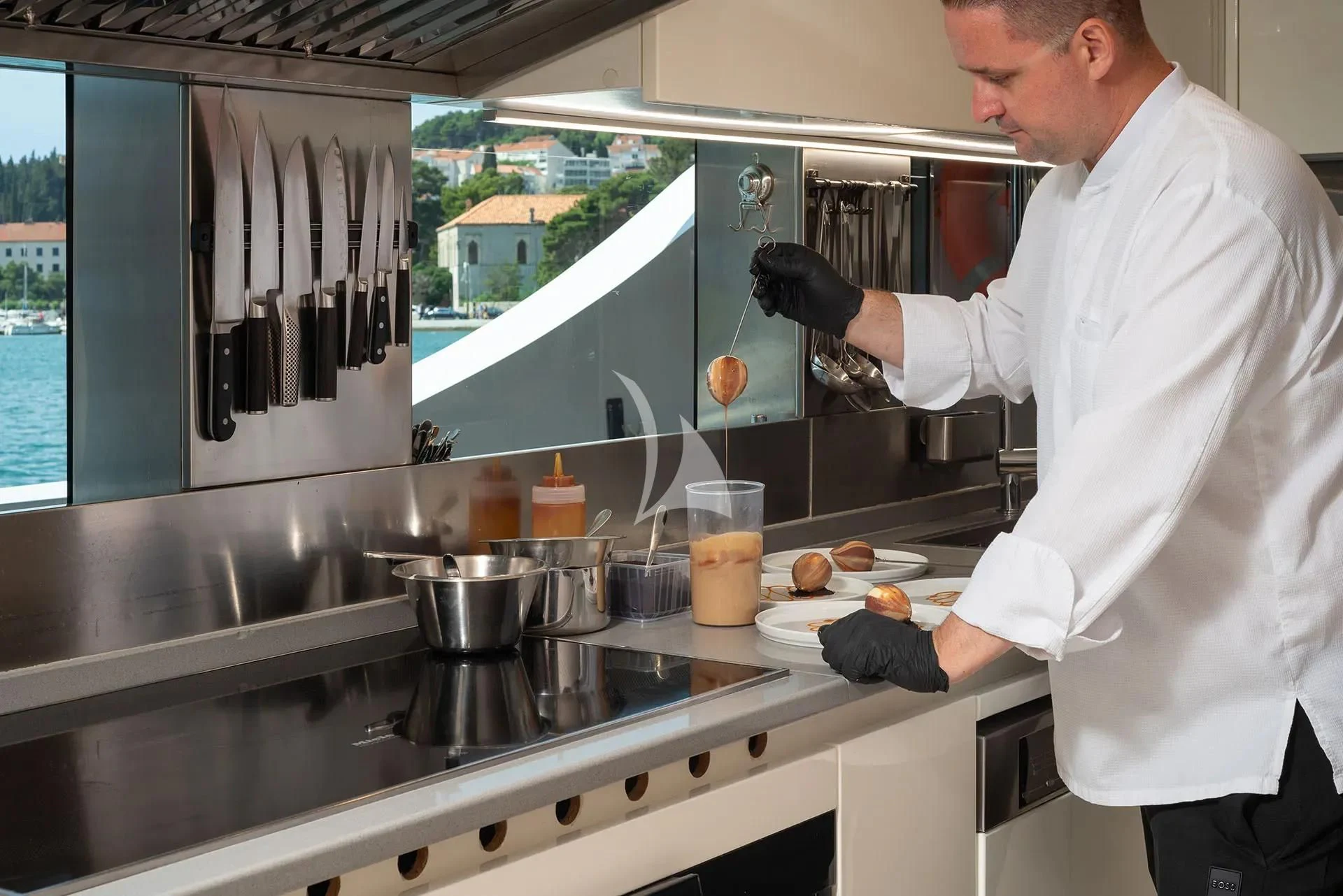 a man in a kitchen preparing food aboard TALEYA Yacht for Sale