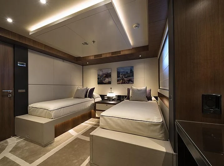 a room with a bed and a television aboard TALEYA Yacht for Sale