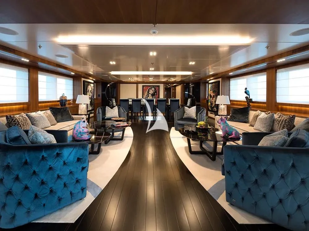 a living room with a large couch and a piano aboard TALEYA Yacht for Sale