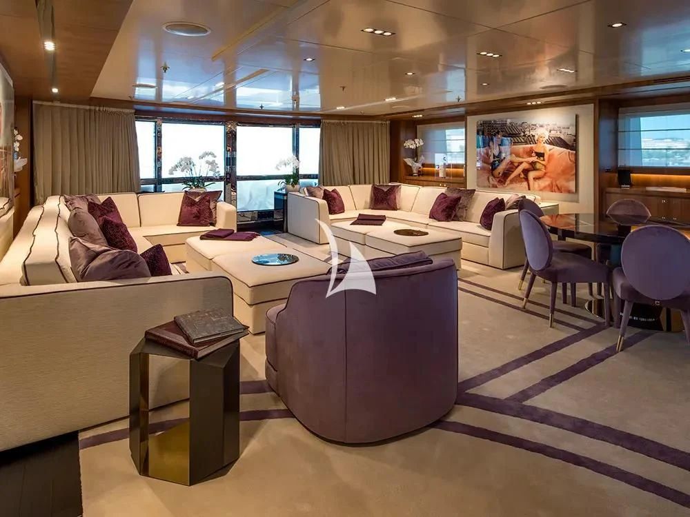 a large living room with a large sofa and a large window aboard TALEYA Yacht for Sale