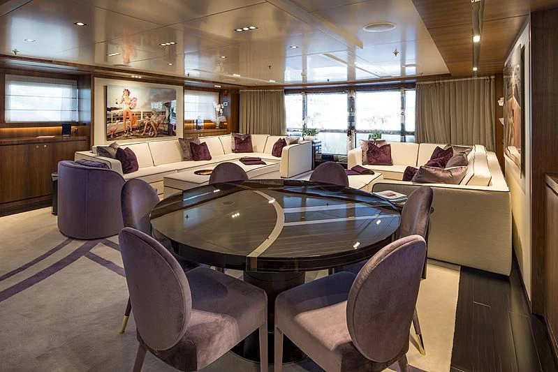 a large room with a table and chairs aboard TALEYA Yacht for Sale