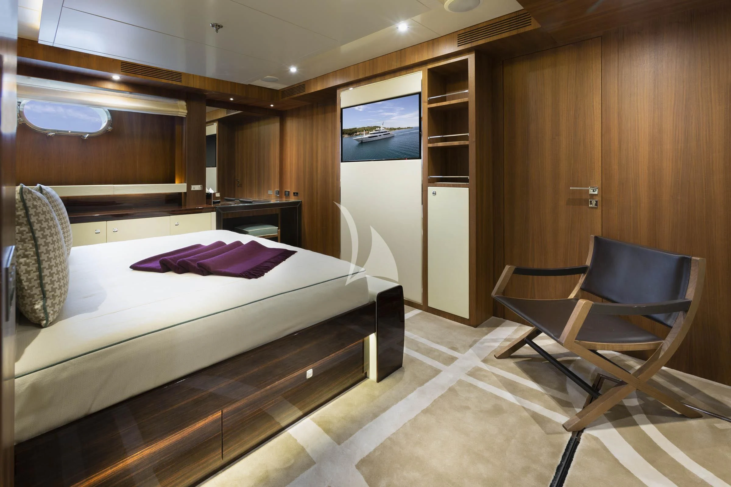 a room with a bed and a chair aboard TALEYA Yacht for Sale
