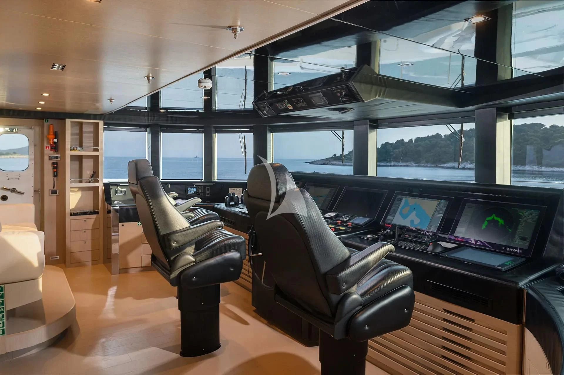 a room with a large window and a desk with computers and chairs aboard TALEYA Yacht for Sale