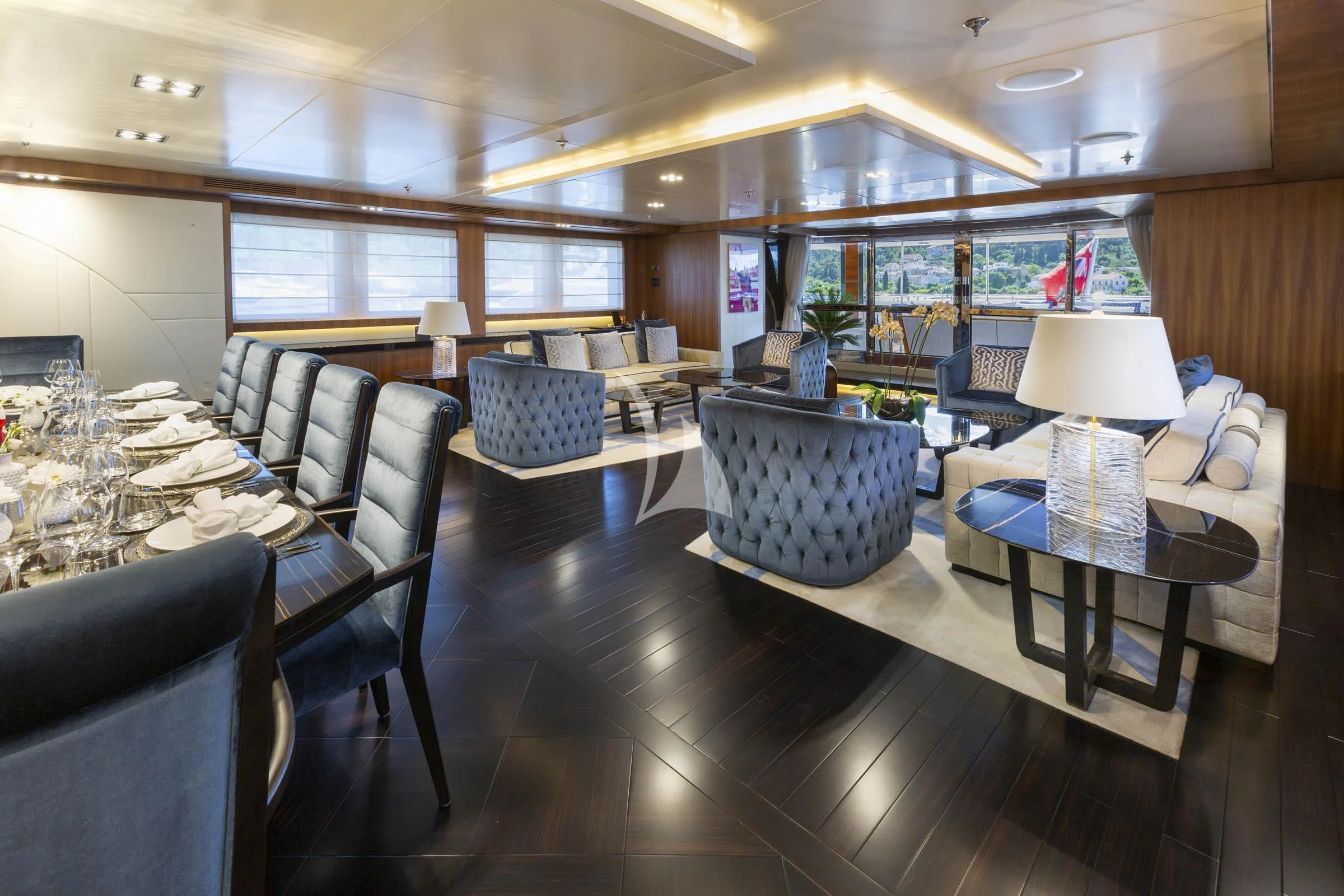 a room with a table chairs and a lamp aboard TALEYA Yacht for Sale