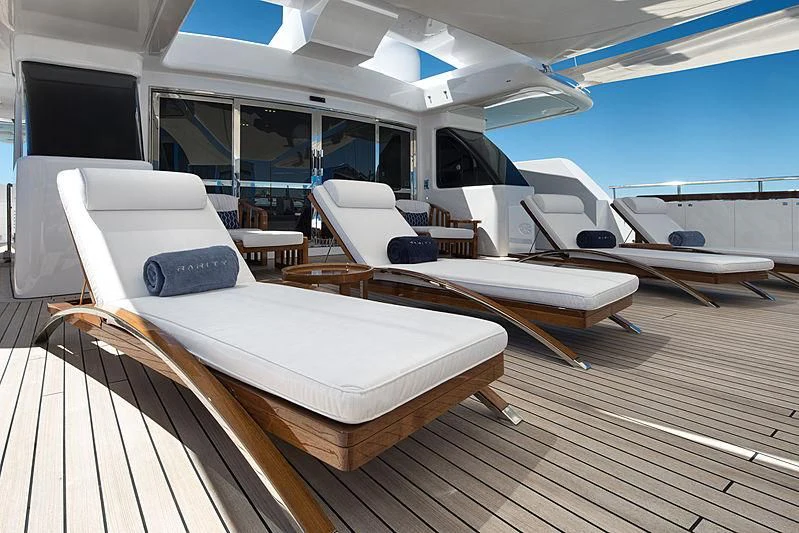 a room with a group of beds aboard TALEYA Yacht for Sale