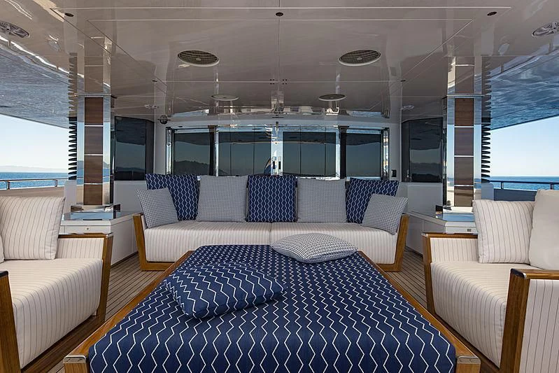 a living room with a blue couch aboard TALEYA Yacht for Sale