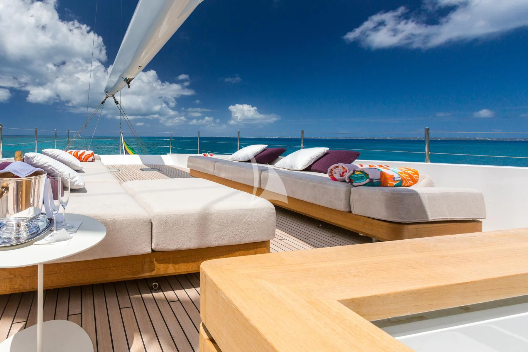 a room with a bed and a table and chairs on a deck aboard SPIRIT OF THE C'S Yacht for Charter