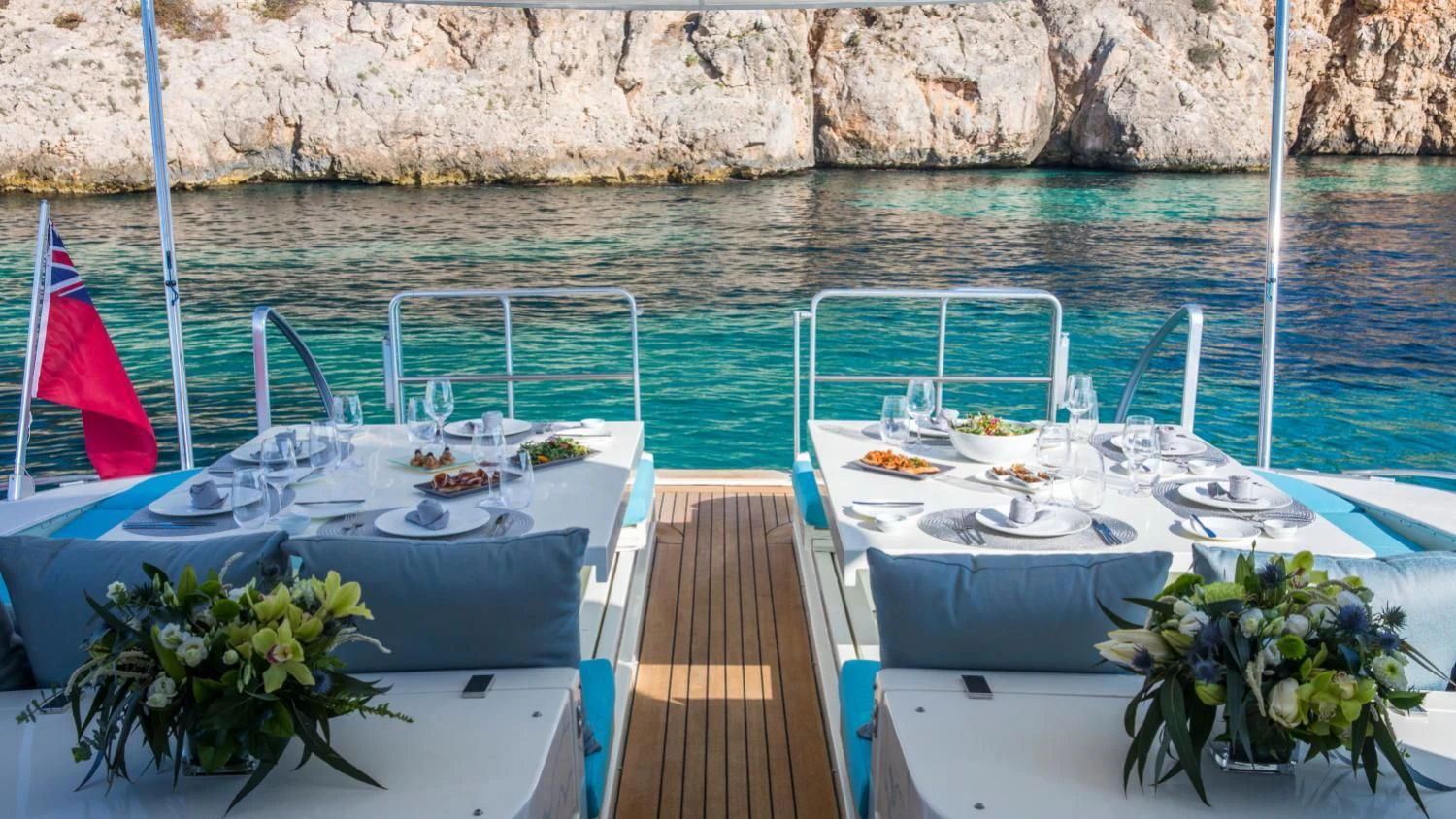 a deck with a table and chairs on it and a body of water in the background aboard CITA Yacht for Sale