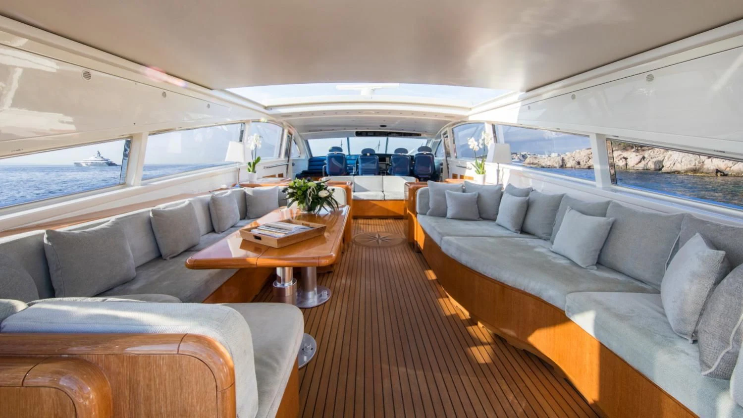a large living room with a wood table and couches aboard CITA Yacht for Sale