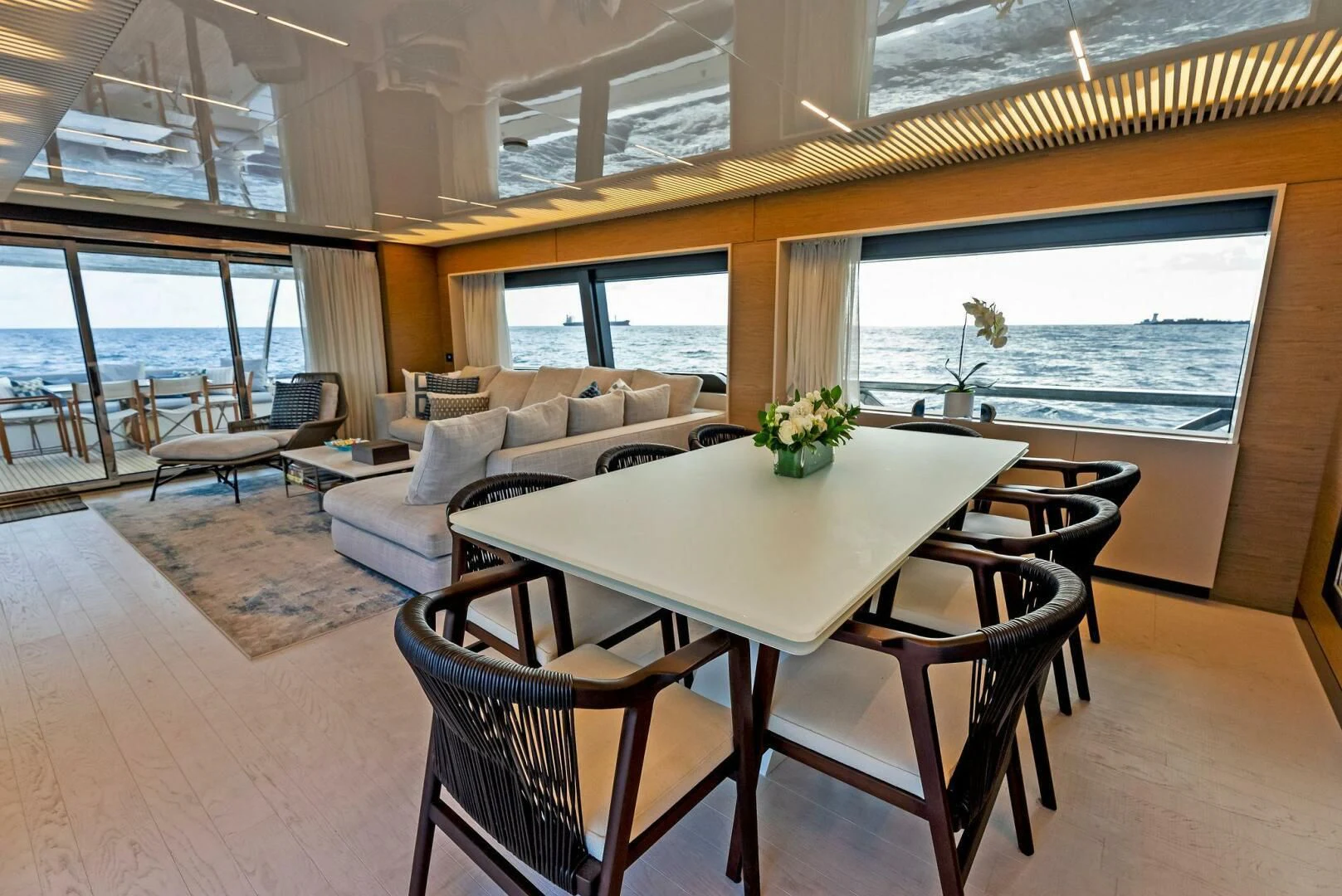 a dining table and chairs in a room with a large window aboard SILHOUETTE Yacht for Sale