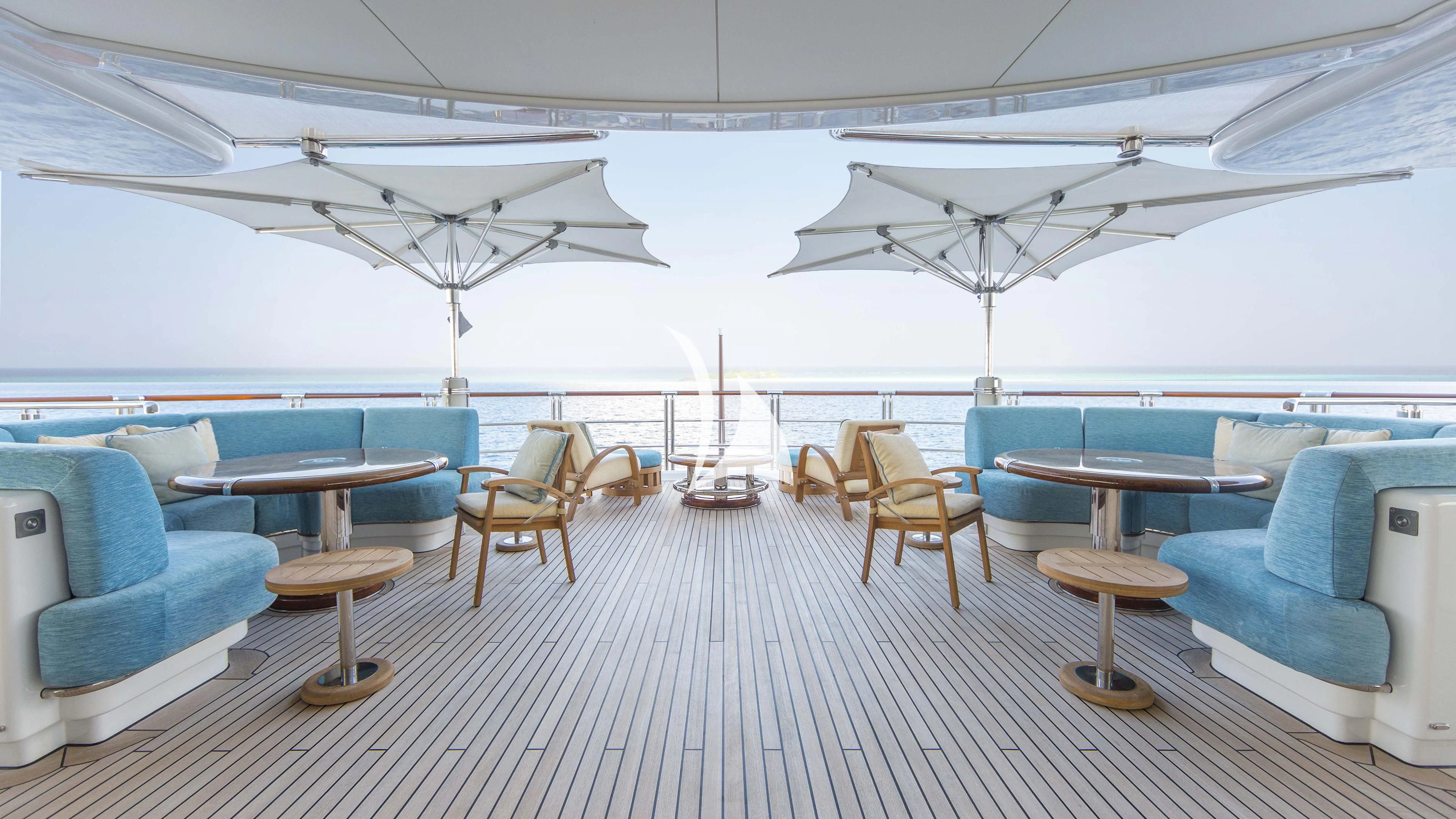 a room with a table chairs and a plane in the background aboard NIRVANA Yacht for Sale