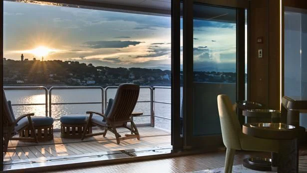 a room with a view of a sunset and a body of water aboard NIRVANA Yacht for Sale