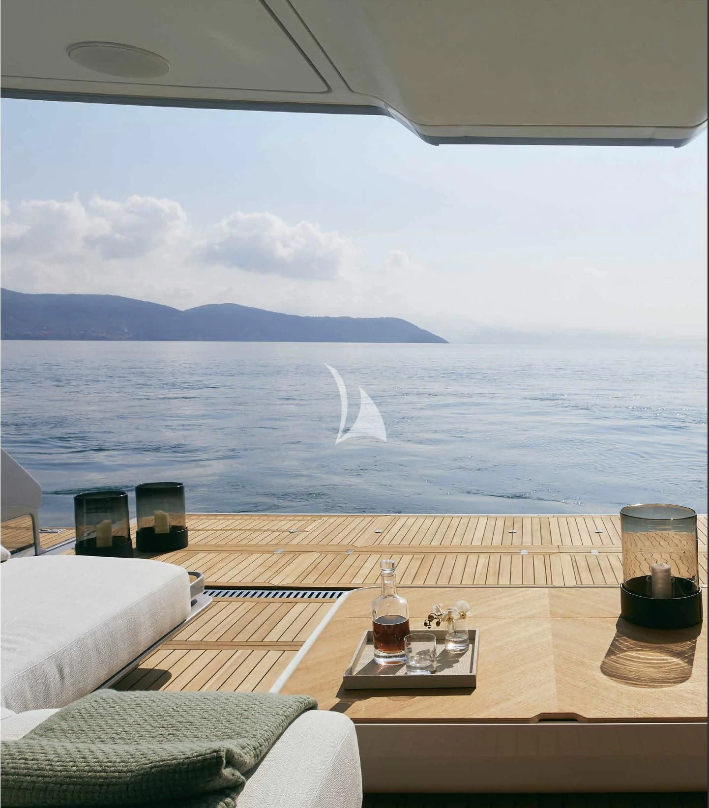 a table with a glass of beer on it by the ocean aboard VOLO MARE Yacht for Charter