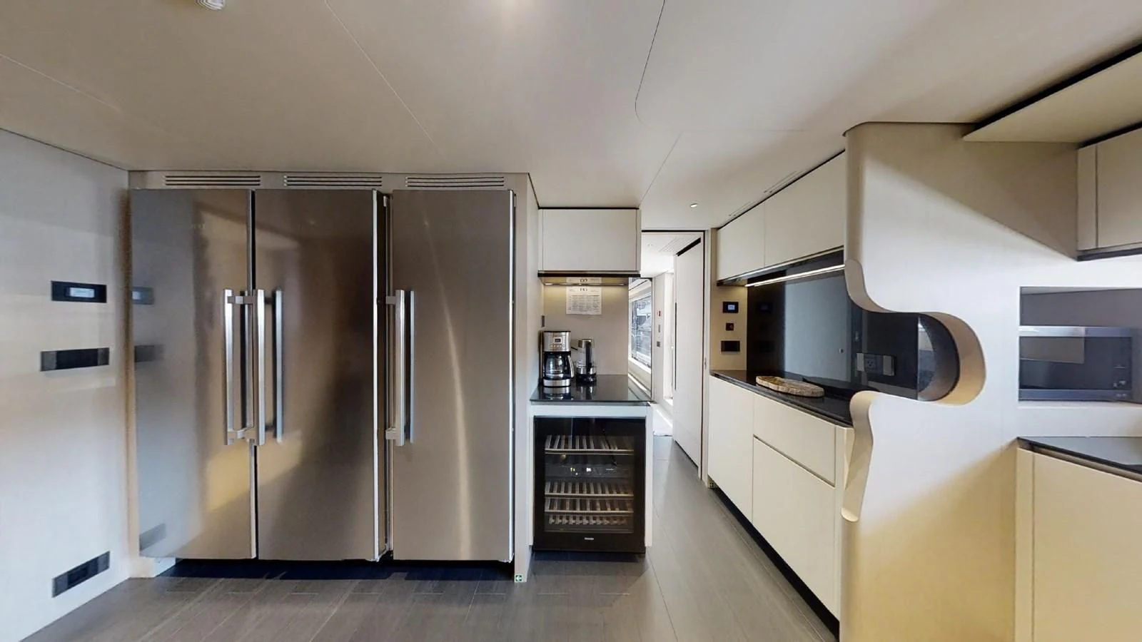 a kitchen with a refrigerator and microwave aboard VOLO MARE Yacht for Charter