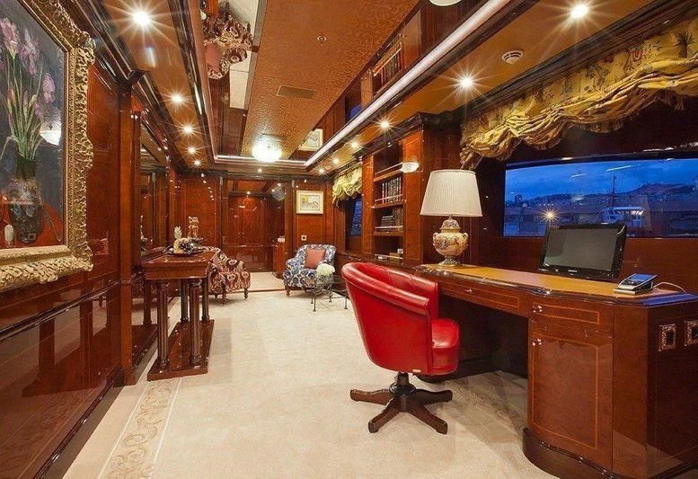 a room with a red chair and a desk with a computer aboard AUSTRALIA Yacht for Sale