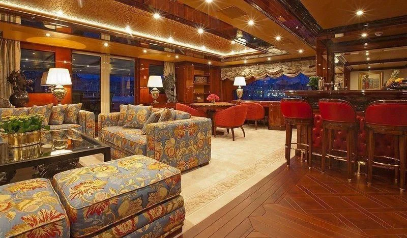 a large living room with a large couch and a table aboard AUSTRALIA Yacht for Sale