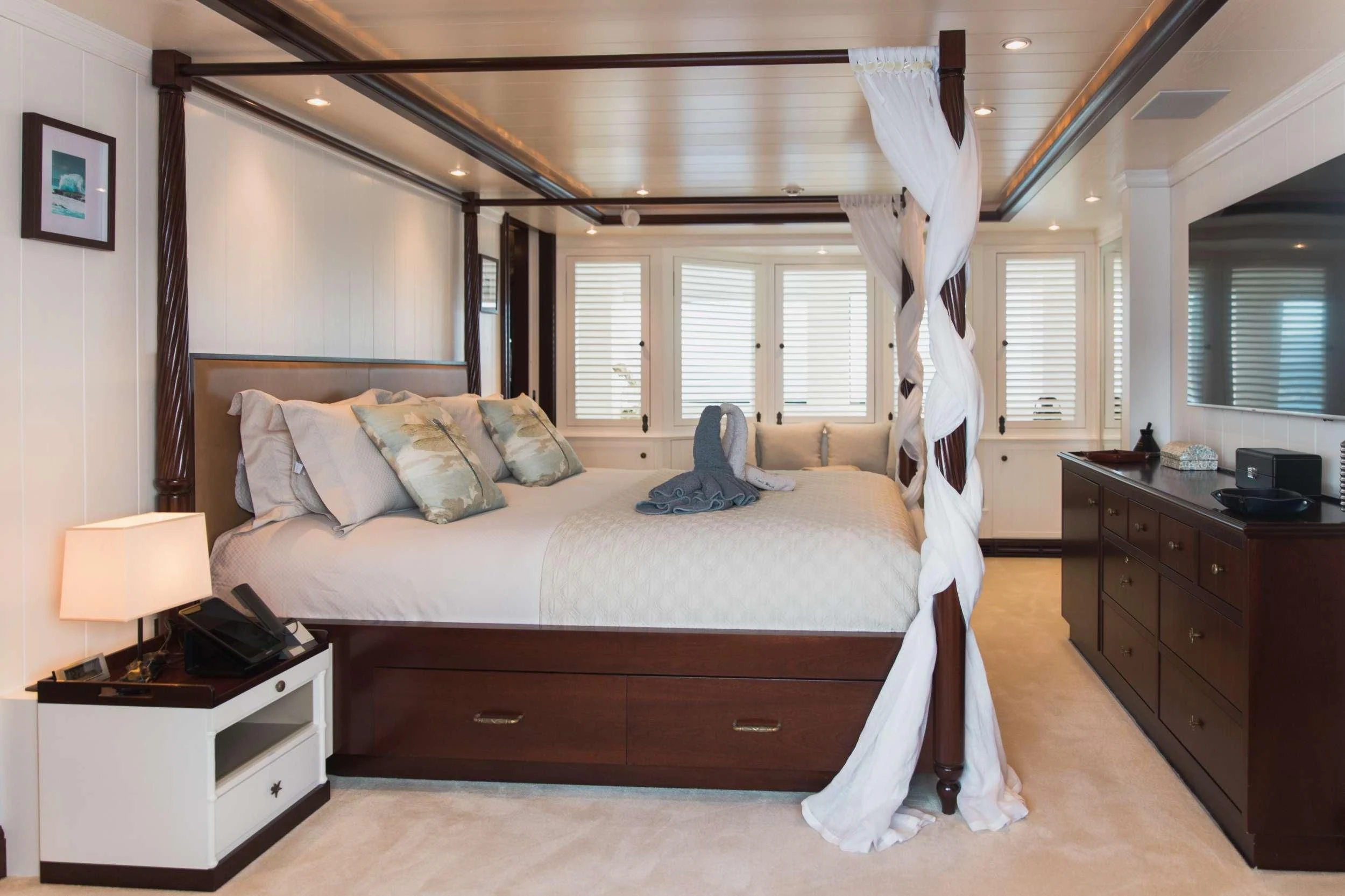 a bedroom with a bed and a dresser aboard LADY TRUDY Yacht for Charter