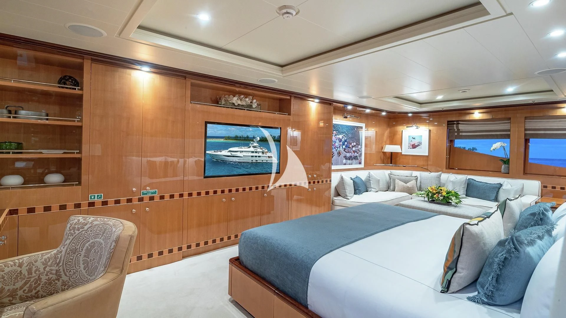 a room with a bed and a chair aboard LIND Yacht for Charter