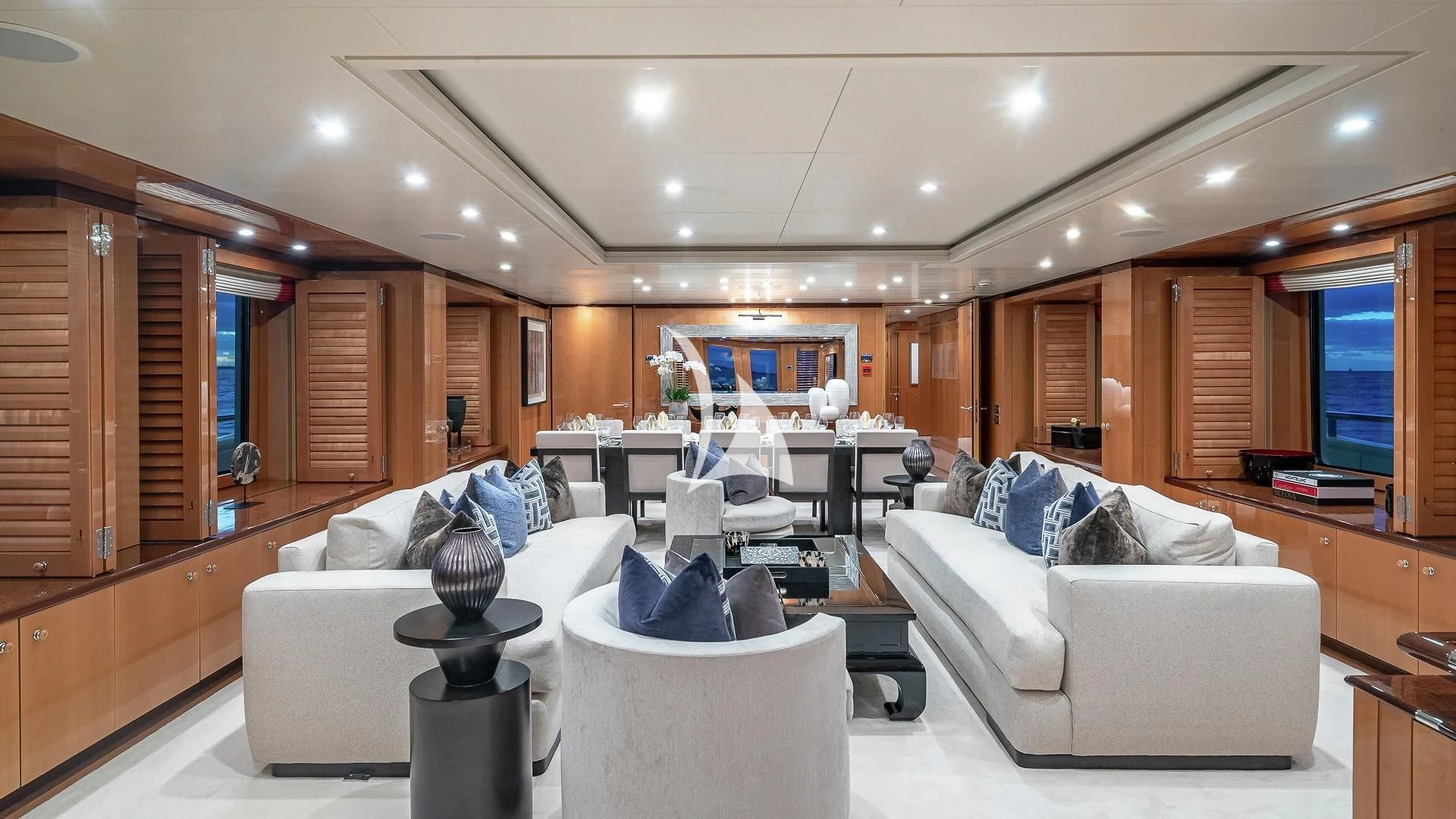 a living room with a white couch and a large wood cabinet aboard LIND Yacht for Charter