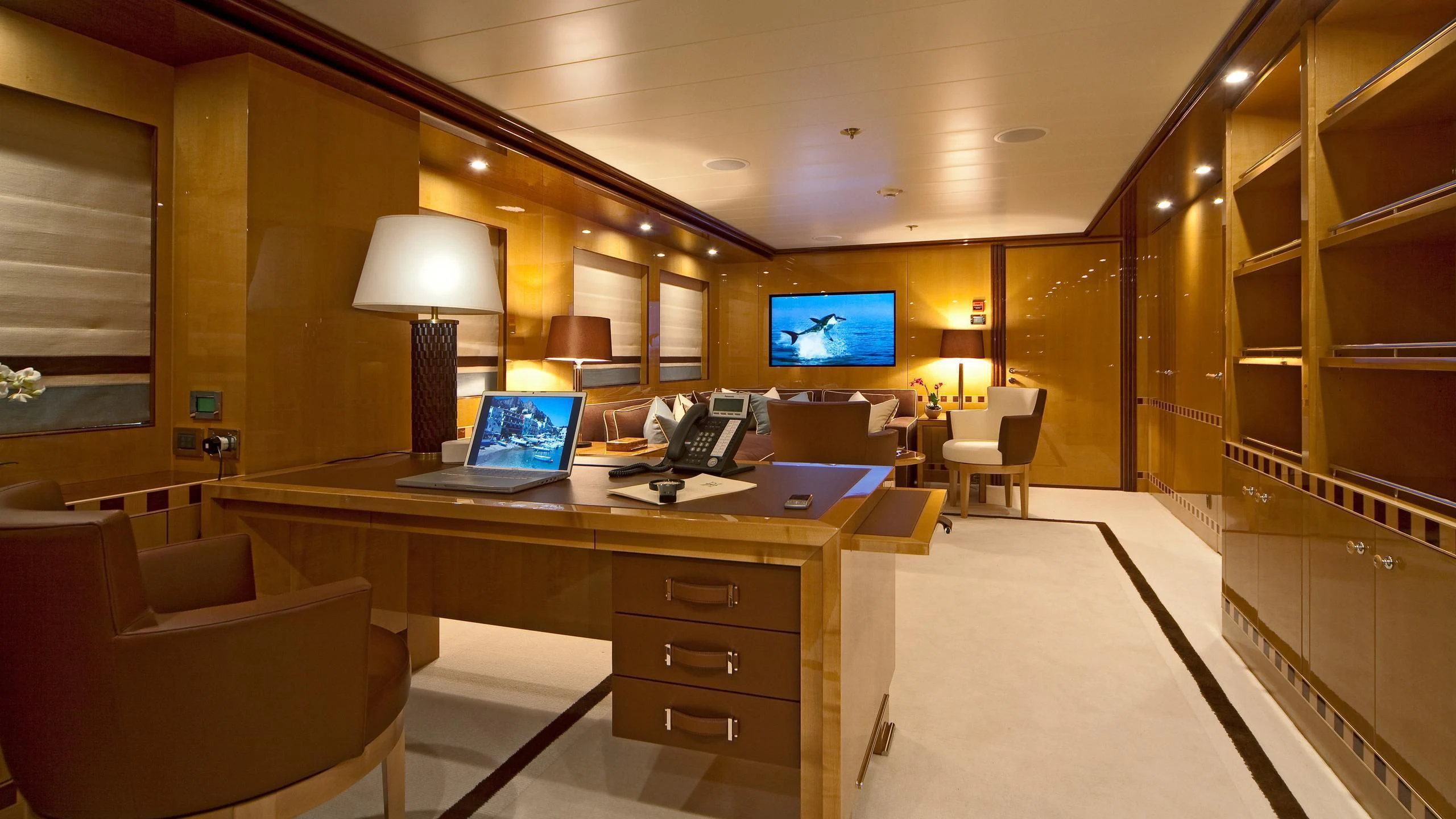 a room with a desk and a tv on the wall aboard LIND Yacht for Charter