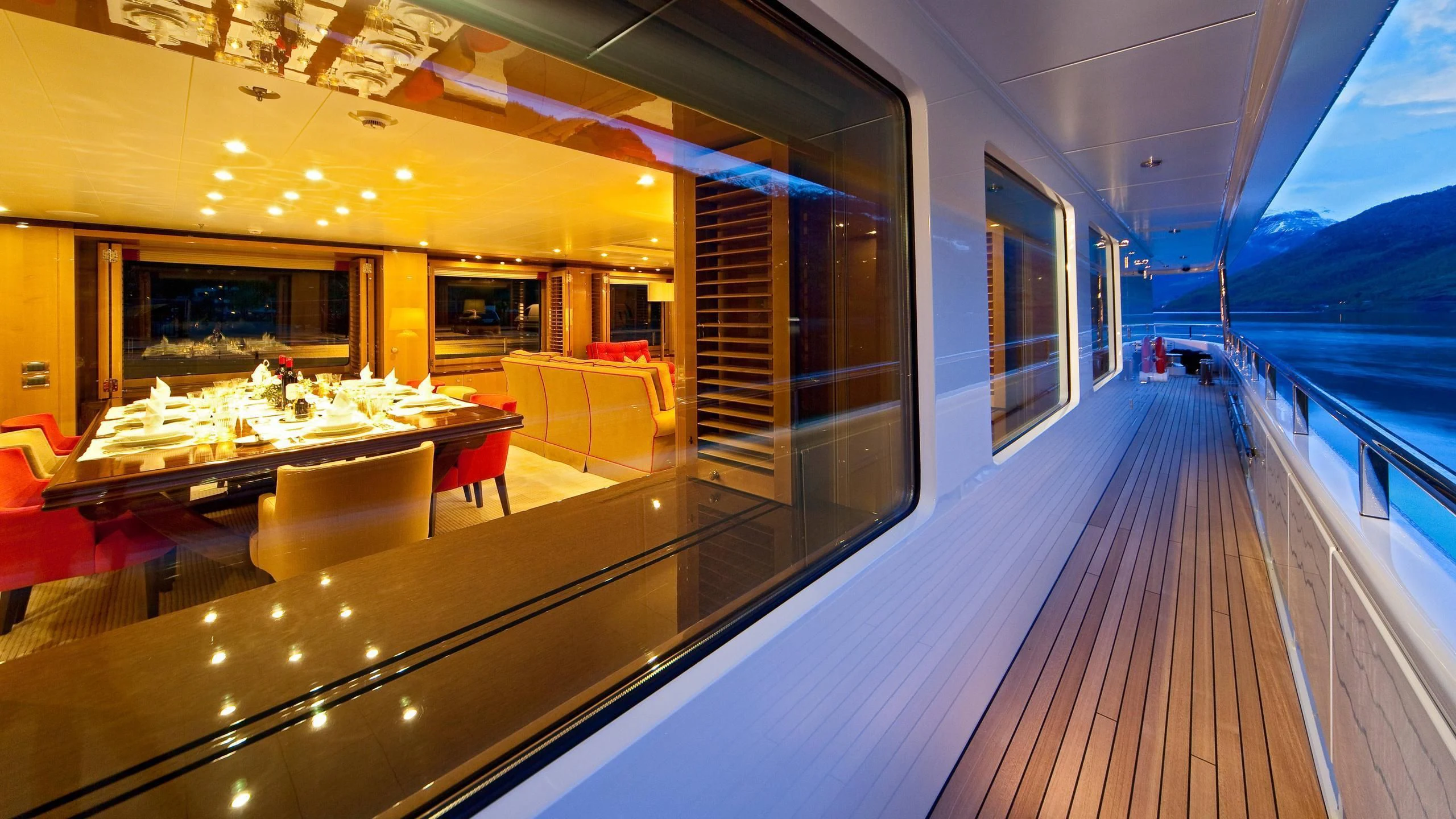 a long wooden deck with a view of a large room with a large window and a view of aboard LIND Yacht for Charter